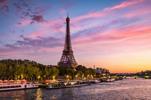 Paris, France - September 24th 2021: Eiffel Tower in Paris under moody vibrant sunset twilight skyscape. View over River Seine towards the iconic Eiffel Tower, River Seine, Champ de Mars, 7th Arrondissement, Paris, France, Europe