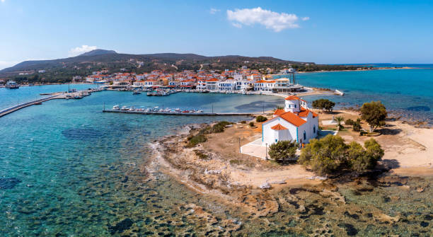 Elafonisos Peloponnese. Greece. Island harbor buildings and Agios Spyridon church, aerial drone view Elafonisos island harbor buildings and Agios Spyridon church, aerial drone view, Peloponnese. Greece. Blue sky and calm sea background. Summer vacation destination peloponnese stock pictures, royalty-free photos & images