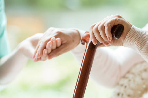 Elder person supported on stick Elder person supported on wooden stick during rehabilitation in friendly hospital assisted living stock pictures, royalty-free photos & images