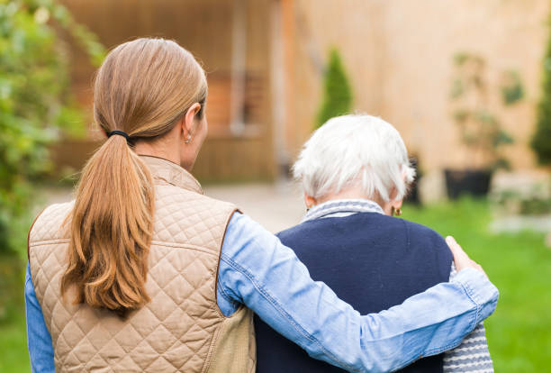 Elderly care Young carer walking with the elderly woman in the park memory loss pics stock pictures, royalty-free photos & images