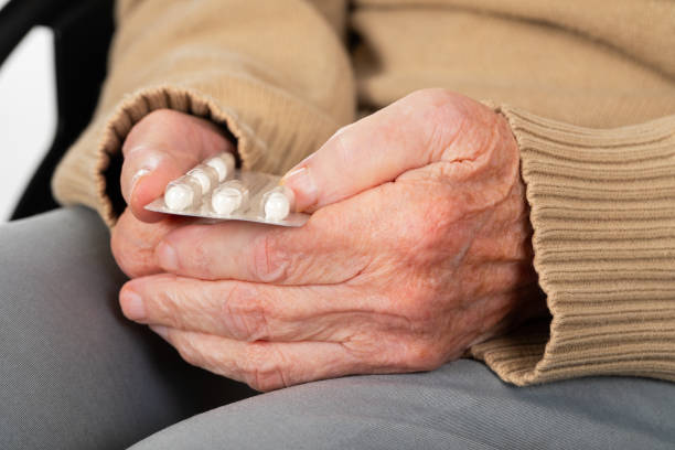 Elderly hands holding pills stock photo