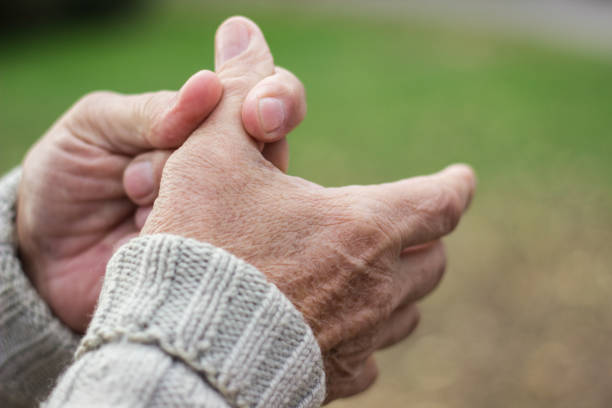 Elderly man has pain in fingers and hands stock photo