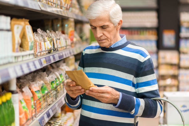 Elderly man shopping cereals in the store stock photo