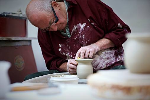 Elderly potter with smart glasses at work
