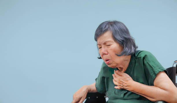 oudere vrouw hoest, choke op rolstoel - choking stockfoto's en -beelden