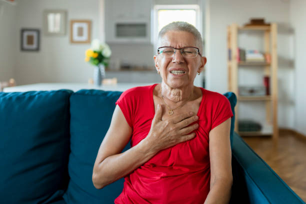Elderly Woman Having Chest Pains or Heart Attack Senior Woman Suffering From Chest Pain While Sitting on Sofa at Home. Old Age, Health Problem, Vision and People Concept. Heart Attack Concept. Elderly Woman Suffering From Chest Pain Indoor chest pain stock pictures, royalty-free photos & images