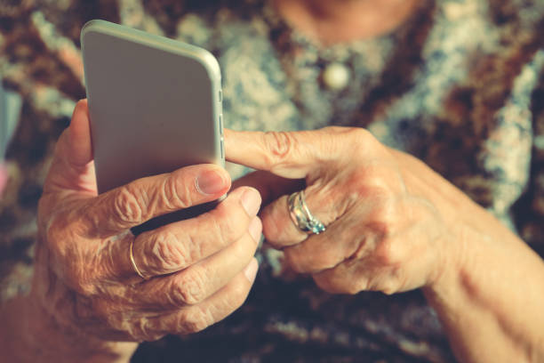 Elderly woman holding a mobile phone stock photo