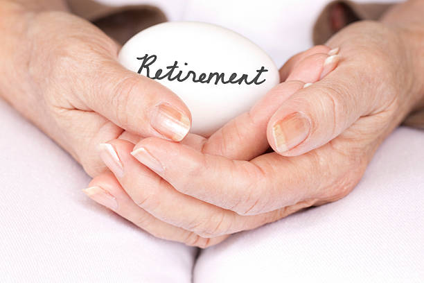 Elderly woman holding retirement egg stock photo