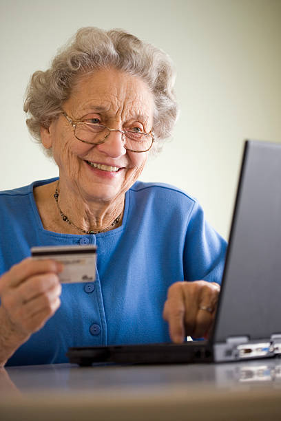 Elderly woman shopping online stock photo