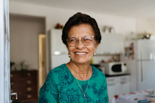 Elderly woman smiling at the kitchen door stock photo