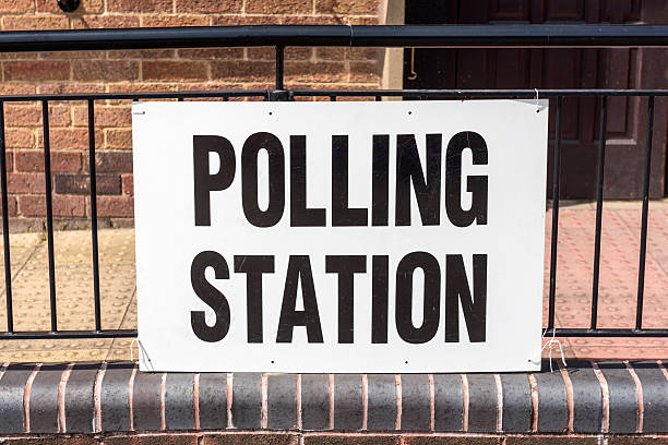 UK election 'Polling Station' sign A 'Polling Station' sign outside village hall during a UK election. polling place stock pictures, royalty-free photos & images