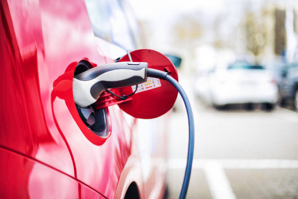 Electric Car charging Red Electric Car during charging,  with copy space battery photos stock pictures, royalty-free photos & images