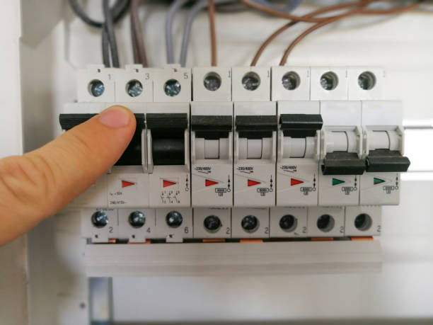 Electric engineer analyzes AC installation inside switch board cabinet stock photo