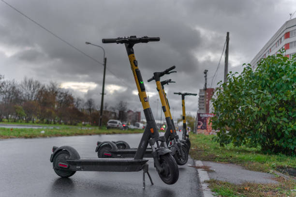 electric scooters stand in a wet row stock photo