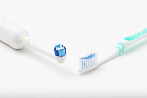 Electric toothbrush versus regular toothbrush stock photo