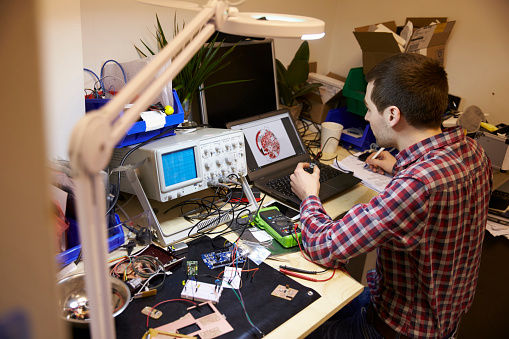 Electrical Engineer Testing Component At Work Bench Stock Photo