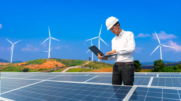 Electrical engineers are using tablets to monitor the operation of the solar cells. Renewable energy concepts. stock photo