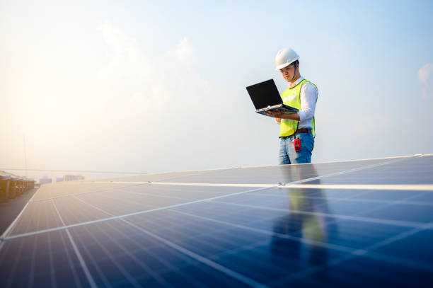 Electrical engineers are using tablets to monitor the operation of the solar cells. stock photo