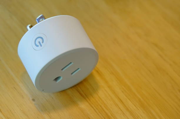 Electrical Outlet plug Smart Wi-Fi Smart Power Socket of White color on Smart Wi-Fi plug  switch with support for control via mobile on floor. electric plug stock pictures, royalty-free photos & images