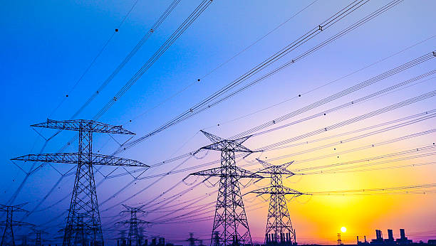Electrical Pylons near Jabel Ali, Dubai, United Arab Emirates Electrical Pylons against vibrant twilight colors and a gorgeous sunset over Dubai Horizon. electricity transformer stock pictures, royalty-free photos & images