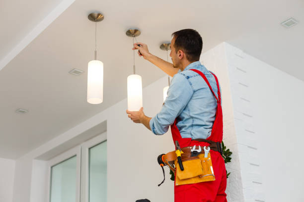 Electrician man worker installing ceiling lamp stock photo