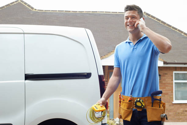 Electrician Standing Next To Van Talking On Mobile Phone stock photo