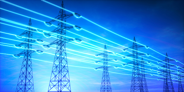 High voltage transmission towers with glowing wires against blue sky - Energy concept