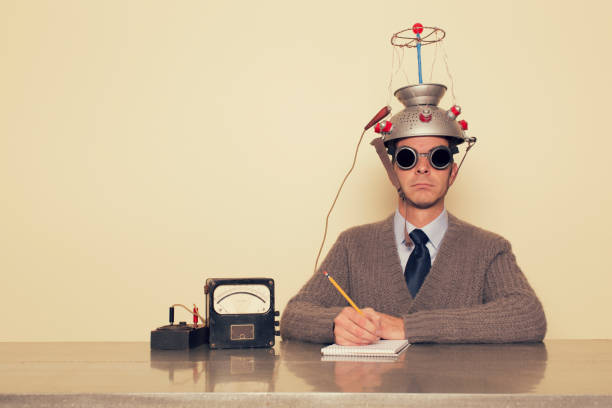 Electro Therapy Man A man is testing the limits of the mind by placing a mind reading invention on his head trying to understand the brain. He is dressed in retro sweater and tie with safety goggles waiting to measure brain waves and understand the unknown. control photos stock pictures, royalty-free photos & images