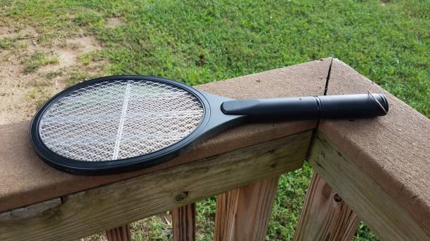 elektronische metalen tennis racket insectenverdelger op houten reling - vliegenmepper stockfoto's en -beelden