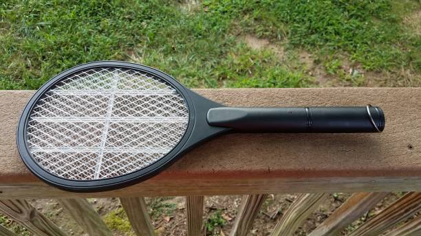 elektronische metalen tennis racket insectenverdelger op houten reling - vliegenmepper stockfoto's en -beelden