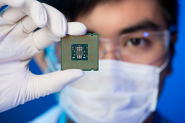 Electronic microchip Cropped image of an engineer showing a computer microchip on the foreground semiconductor stock pictures, royalty-free photos & images