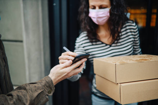 Electronic signature of the package delivery during coronavirus pandemic stock photo
