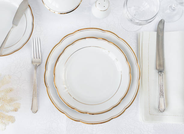 Elegance table setting Beautifully decorated table with white plates, glasses, antique cutlery and white coral on luxurious tablecloths porcelain stock pictures, royalty-free photos & images
