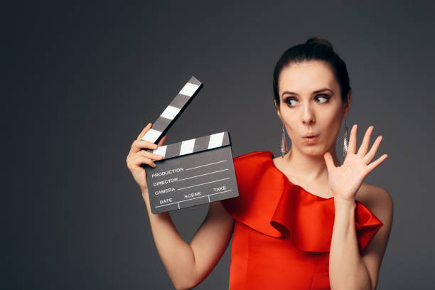 Elegant Actress in Red Dress Holding Cinema Clapboard Glamorous television host ready to start a show actress stock pictures, royalty-free photos & images