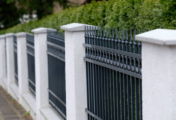 Elegant grey iron fence with white pillars stock photo