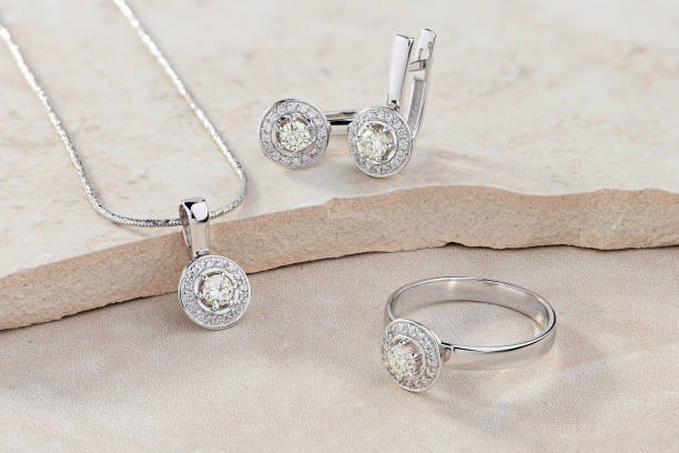 Elegant jewelry set of white gold ring, necklace and earrings with diamonds Elegant jewelry set of white gold ring, necklace and earrings with diamonds. Silver jewellery set with gemstones. Product still life concept jewelry stock pictures, royalty-free photos & images