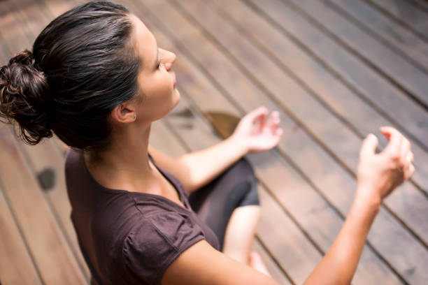 Elevated view of woman meditating Elevated view of young woman meditating image technique stock pictures, royalty-free photos & images