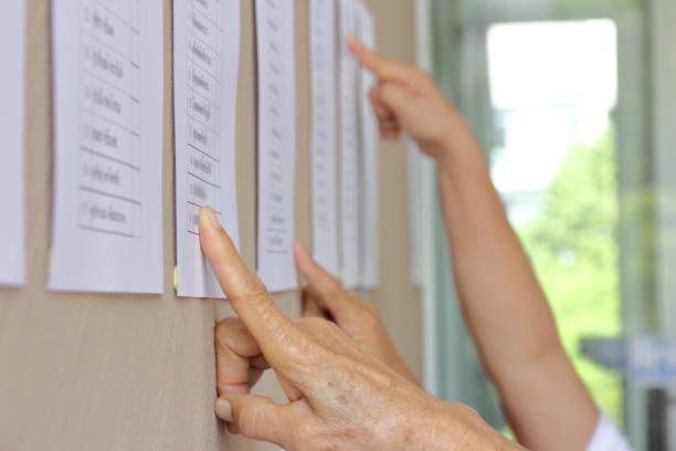 Eligible voters checking for their name at polling booth before the election, with blurred name stock photo