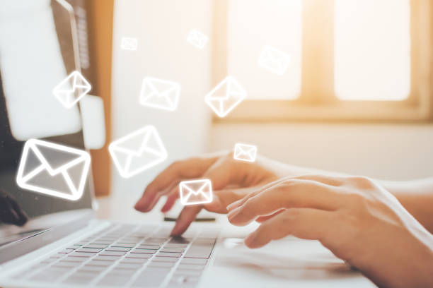 e-mail marketing en nieuwsbrief concept. hand van man verzenden bericht en laptop met e-mail pictogram - email stockfoto's en -beelden