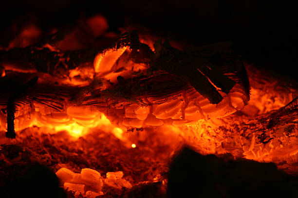 Embers Glow of a log on a fire. Shallow depth of field and soft focus appearance from long exposure glow. firewalking stock pictures, royalty-free photos & images