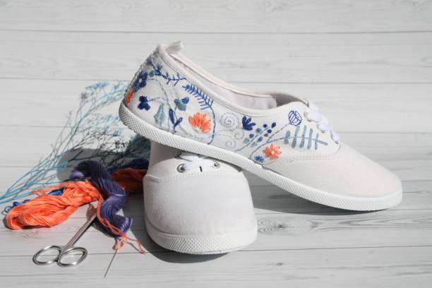 embroidered floral pattern on white sneakers create a fashionable image stock photo