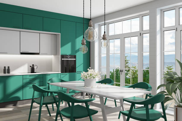 Emerald green and white Modern Scandinavian kitchen with large dining table and chairs. Large windows. Open space kitchen concept. Summer scene. stock photo