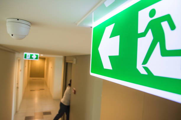 Emergency Fire exit sign at  the corridor in building Emergency Fire exit sign at  the corridor in building evacuation stock pictures, royalty-free photos & images