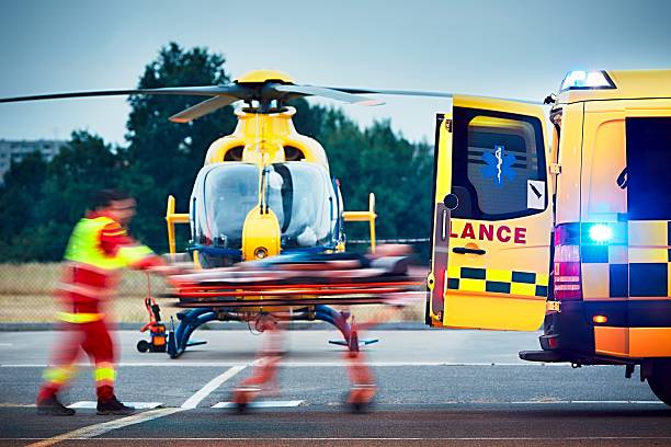 Emergency medical service Cooperation between air rescue service and emergency medical service on the ground. Paramedic is pulling stretcher with patient to the ambulance car. helicopter stock pictures, royalty-free photos & images