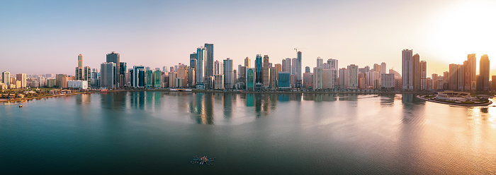 Panoramic view at Emirate of Sharjah cityscape waterfront rising above Al Noor Island at city downtown in the United Arab Emirates