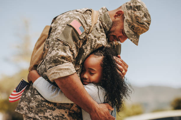 Emotional soldier saying farewell to his daughter stock photo