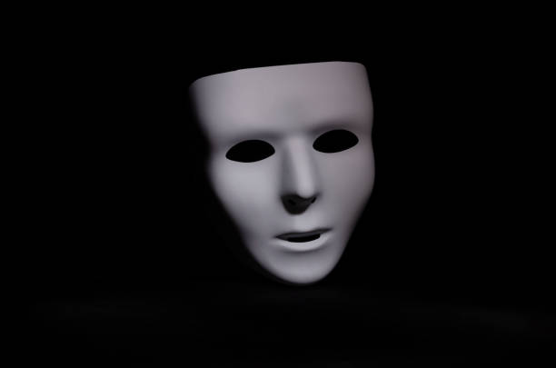 emotionless white mask on black background stock photo
