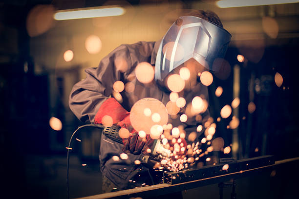 Employee grinding steel with sparks Employee grinding steel with sparks grinding stock pictures, royalty-free photos & images