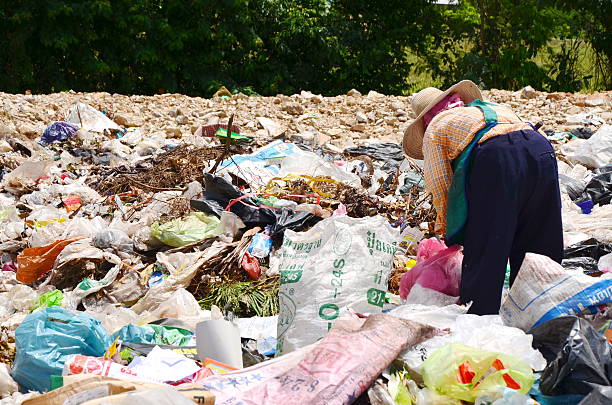 Employees and Scavengers are processing waste in Dump site Ratchaburee City, Thailand - June 5, 2012: Employees and Scavengers are processing waste in Dump site at Ratchaburee City Thailand on May 6, 2012. People searching for refuse to recycle or resell scavenging stock pictures, royalty-free photos & images