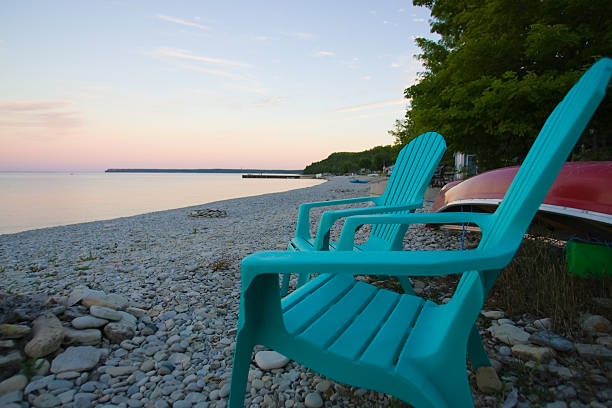 Empty Adirondack chairs on the beach stock photo